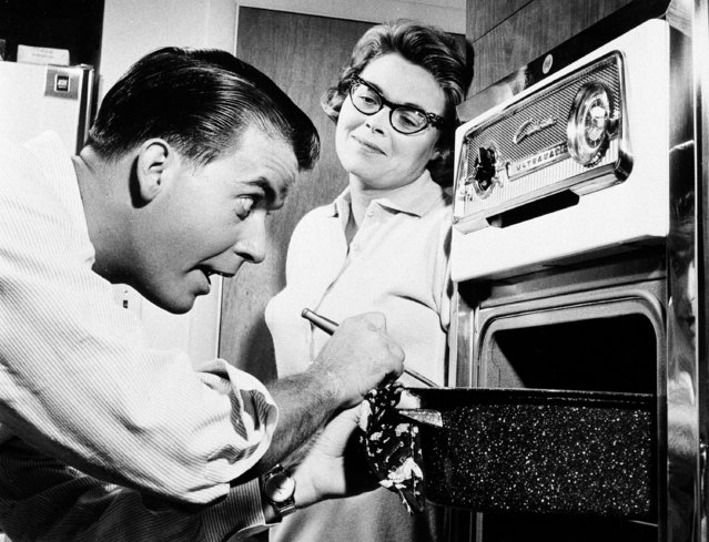 As his wife Barbara Mallery looks on Dick Clark does a bit of kitchen policing at their new suburban home near Philadelphia, PA., July 26, 1960. (Photo by AP Photo)