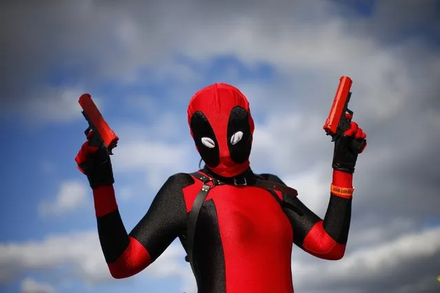 A woman disguised as “Lady Deadpool”, a Marvel comic character, poses outside the MCM Comic Con at the Excel Centre in East London, October 25, 2014. (Photo by Andrew Winning/Reuters)