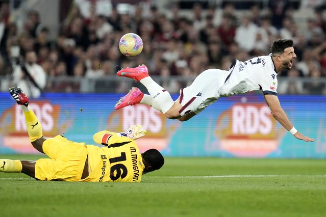 AC Milan's goalkeeper Mike Maignan, left, and Bologna's Riccardo Orsolini challenge for the ball during the Italian Cup final soccer match between AC Milan and Bologna at Rome's Olympic Stadium, Wednesday, May 14, 2025. (Photo by Gregorio Borgia/AP Photo)