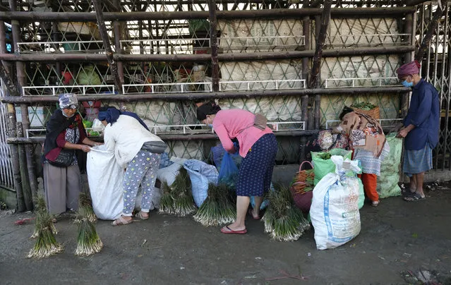 Naga women hold sacks containing local vegetables at a market early morning in Kohima, capital of the northeastern Indian state of Nagaland, Tuesday, June 30, 2020. Several Indian states have reimposed partial or full lockdowns to stem the spread of the coronavirus. (Photo by Yirmiyan Arthur/AP Photo)