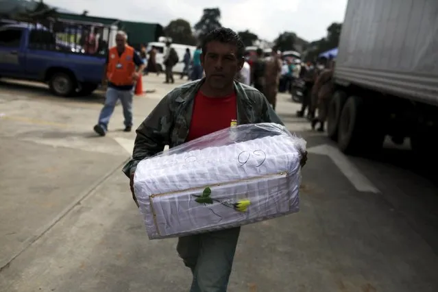 A volunteer carries a coffin outside a morgue in Santa Catarina Pinula, on the outskirts of Guatemala City, October 5, 2015. (Photo by Jose Cabezas/Reuters)