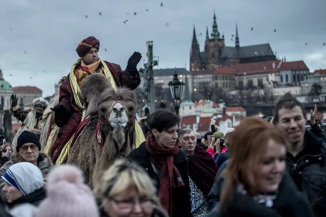 Men dressed as the Three Kings ride camels during the “Three Wise Men” procession on the medieval Charles bridge in Prague, Czech Republic, 05 January 2018. The procession, which annually marks the end of the Christmas festivities in Prague, is a re-enactment of the journey of the Three Wise Men to visit the infant Jesus. (Photo by Martin Divisek/EPA/EFE)