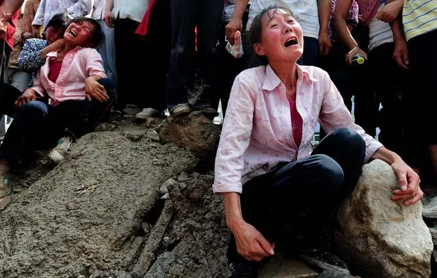 Relatives grieve the loss of a loved one, pulled out from the mud and rubble of the devastating landslide in Zhouqu in northwest China's Gansu province. (Photo by Frederic J. Brown/AFP Photo)