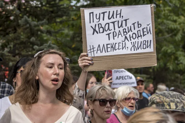 People hold a poster reading "Putin, stop poisoning people, Alexei you must live" during an unsanctioned protest in support of Sergei Furgal, the governor of the Khabarovsk region, in Khabarovsk, 6,100 kilometers (3,800 miles) east of Moscow, Russia, Saturday, August 22, 2020. Russian dissident Alexei Navalny, who is in a coma after a suspected poisoning, has arrived in Berlin on a special flight for treatment by specialists. The politician and corruption investigator who is one of Russian President Vladimir Putin's fiercest critics was thought to be in stable condition on arrival Saturday and is to be treated in the German capital's main hospital. (Photo by Igor Volkov/AP Photo)