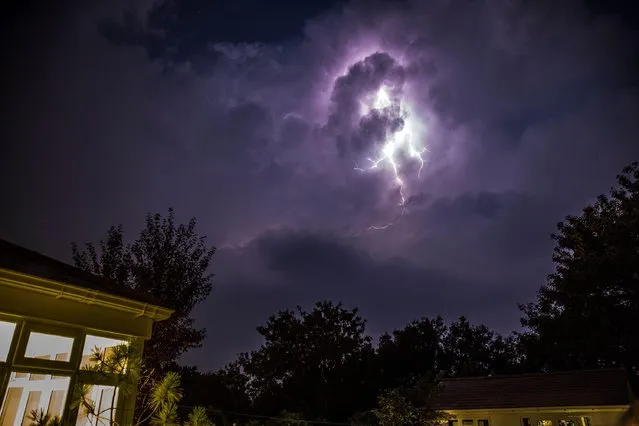 Lightning breaks dramatically through the clouds above the garden of a residential property in Kidderminster, UK as nighttime thunderstorms hit the county of Worcestershire on August 11, 2020. (Photo by Lee Hudson/Alamy Live News)