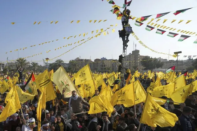 Palestinian Fatah supporters chant slogans and wave the movement's flags during a rally marking the 58th anniversary of Fatah movement foundation at the Unknown soldier square in Gaza City, Saturday, December 31, 2022. Hundreds of thousands of Palestinians thronged a Gaza City park Saturday to mark the 58th founding anniversary of Fatah party, a rare show of popularity in the heartland of the militant Hamas group, Fatah's main rival. (Photo by Adel Hana/AP Photo)