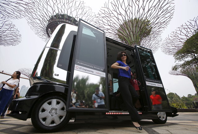 Members of the media disembark from an autonomous vehicle during a demonstration in Singapore, October 2015. (Photo by Edgar Su/Reuters)