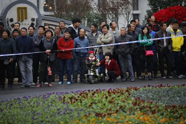 Local residents watch an inauguration ceremony of a Hello Kitty amusement park in Anji, Zhejiang province November 28, 2014. (Photo by Carlos Barria/Reuters)