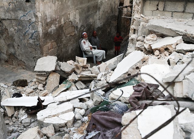 A child walks next to Palestinian men at the site of an overnight Israeli air strike on a house, in Gaza City on July 11, 2025. (Photo by Mahmoud Issa/Reuters)