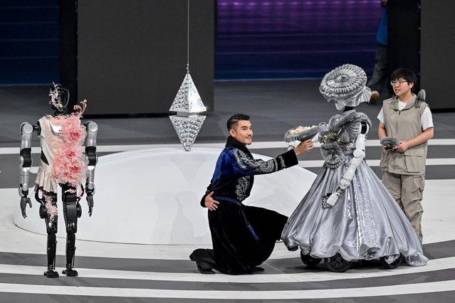 People and robots take part in the opening ceremony of the World Humanoid Robot Games in Beijing on August 14, 2025. (Photo by Adek Berry/AFP Photo)