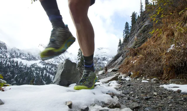 Andrew O'Connor and his dog Pepper run on Snow Lake Trail, Tuesday, November 3, 2015, above Snoqualmie Pass in Washington state. Some of the first snow of the season fell in the area over the weekend, but that didn't stop several hikers from enjoying the trail. (Photo by Ted S. Warren/AP Photo)