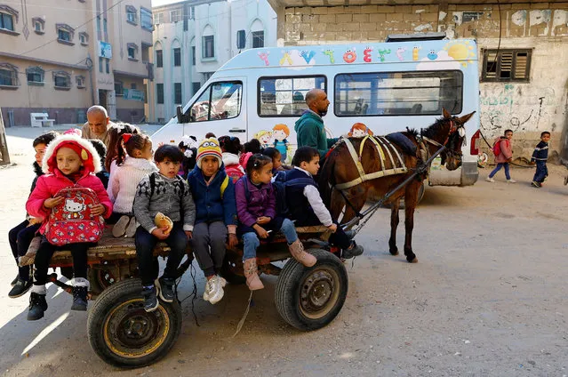 Palestinian man Loay Abu Sahloul offers to some students a low-cost donkey-cart ride to kindergarten in Khan Younis, southern Gaza Strip on February 25, 2023. (Photo by Ibraheem Abu Mustafa/Reuters)