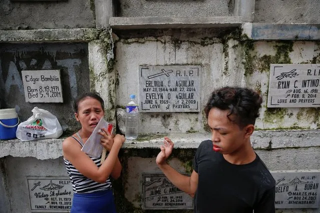 The sister of Gilbert Purgatorio, who was killed by masked gunmen, cries during his and a relative's funeral at a cemetery in Manila, Philippines October 11, 2016. Gilbert Purgatorio, who, according to a relative, used to take drugs but stopped when Rodrigo Duterte became the president, was killed on his 27th birthday together with his cousin Gerard G. Cruz near their home in Manila. (Photo by Damir Sagolj/Reuters)