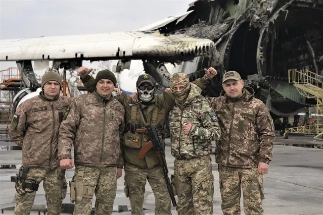 Ukrainian soldiers of mobile air defence units pose for a photo at the Antonov airport, in front of the gutted remains of the Antonov An-225, the world's biggest cargo aircraft, destroyed during fighting between Russian and Ukrainian forces, in Hostomel, on the outskirts of Kyiv, Ukraine, Saturday, April 1, 2023. (Photo by Efrem Lukatsky/AP Photo)