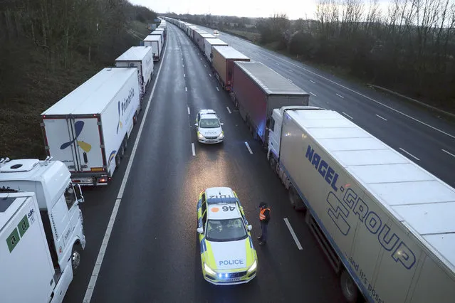 Police patrol along the M20 motorway where freight traffic is halted whilst the Port of Dover remains closed, in Ashford, Kent, England, Tuesday, December 22, 2020. Trucks waiting to get out of Britain backed up for miles and people were left stranded at airports as dozens of countries around the world slapped tough travel restrictions on the U.K. because of a new and seemingly more contagious strain of the coronavirus in England. (Photo by Andrew Matthews/PA Wire via AP Photo)
