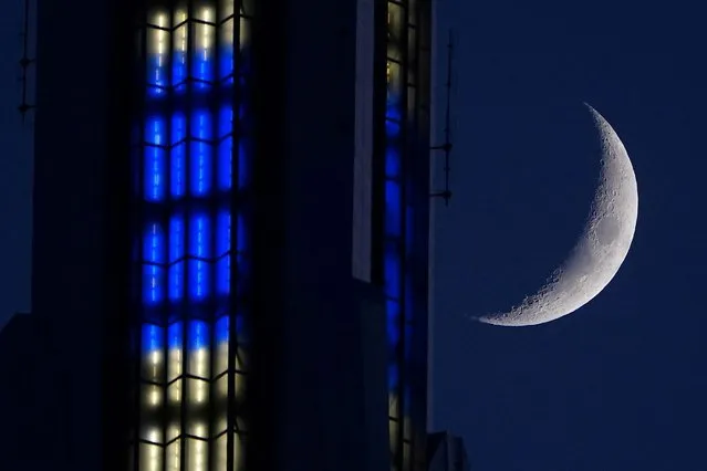 A waxing crescent moon is pictured next to the Empire State building lit in blue and white to honor Chanukah, as seen from Bryant Park at dusk the day after a nor'easter storm in Manhattan, New York, December 18, 2020. (Photo by Carlo Allegri/Reuters)