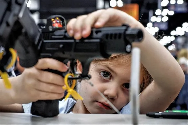 A child holds a gun at the National Rifle Association (NRA) annual convention in Indianapolis, Indiana, U.S., April 15, 2023. (Photo by Evelyn Hockstein/Reuters)