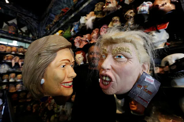 An employee holds up masks depicting Democratic presidential nominee Hillary Clinton and Republican presidential nominee Donald Trump at Hollywood Toys & Costumes in Los Angeles, California U.S., October 26, 2016. (Photo by Mario Anzuoni/Reuters)