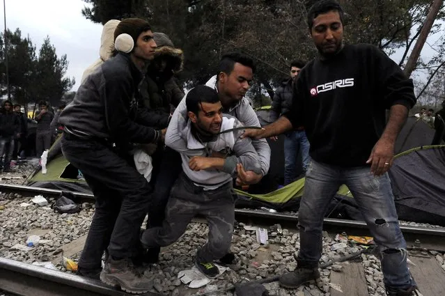 A migrant, who witnesses said to have deliberately injured himself during a demonstration, is carried away as migrants wait to cross the Greek-Macedonian borders near the village of Idomeni, Greece, November 22, 2015. (Photo by Alexandros Avramidis/Reuters)