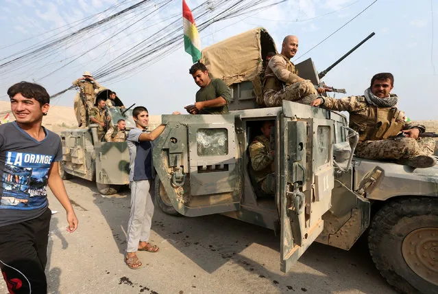 Kurdish peshmerga fighters celebrate after recapturing the Fadiliya village from Islamic state militants, in Nawaran, north of Mosul, Iraq, October 27, 2016. (Photo by Air Jalal/Reuters)