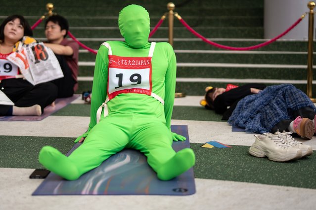 Participants compete to do nothing during the Space-out competition at World Expo 2025 on September 27, 2025 in Osaka, Japan. For 90 minutes, participants sat in silence, trying to remain in a dazed state without distraction. The winner was determined not by activity but by calmness maintaining the most stable heart rate amid the lively crowds of the Osaka Expo site. (Photo by Tomohiro Ohsumi/Getty Images)