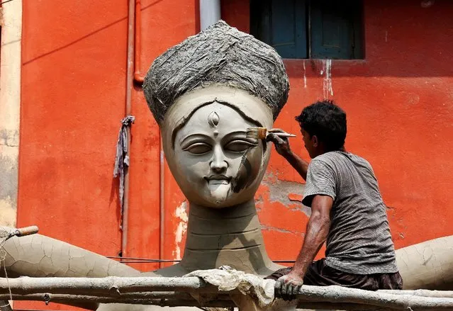 An artist paints the face of an idol of the Hindu goddess Kali at a roadside workshop ahead of the Kali Puja festival in Kolkata, India October 24, 2016. (Photo by Rupak De Chowdhuri/Reuters)