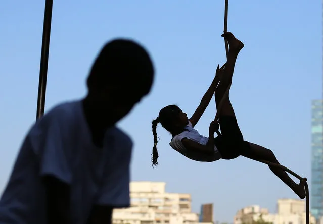 An Indian student practices her grip and posture during a training session of Rope Mallakhamb, during the 44th Samartha Summer Sports Coaching Camp organized by Shree Samarth Vyayam Mandir in Mumbai, India, 25 April 2018. (Photo by Divyakant Solanki/EPA/EFE)