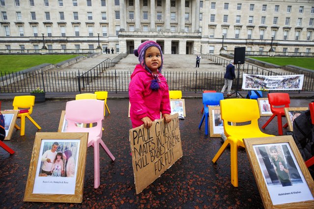 Eirinn Harper, 2, from Kilcoo, holds a sign as she stands beside children's seat at Stormont, UK on November 3, 2025 with images of Palestinian children who have died with school bags and shoes during the conflict before a planned demonstration outside Parliament Buildings, Stormont, calling for Stormont Education Minister Paul Givan to resign following his trip to Israel last week. (Photo by Liam McBurney/PA Wire)