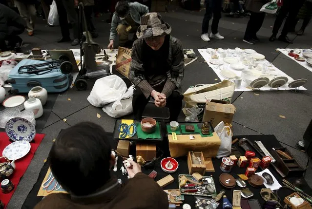 A shop clerk chats with a customer at a flea market at a shopping district in Tokyo, Japan, December 6, 2015. (Photo by Yuya Shino/Reuters)