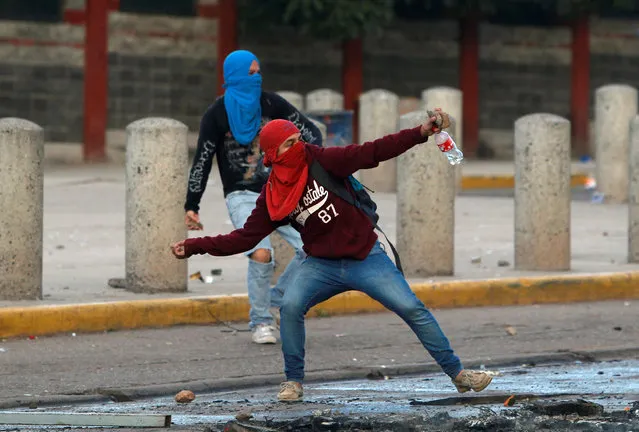 Masked students throw stones towards riot policemen (not pictured) during a protest against the re-election of Honduran President Juan Orlando Hernandez in the 2017 election, in Tegucigalpa, Honduras, November 9, 2016. (Photo by Jorge Cabrera/Reuters)