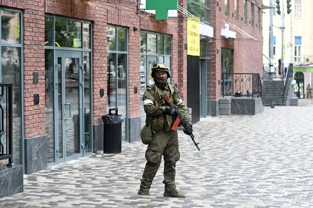 A fighter of Wagner private mercenary group stands guard in a street near the headquarters of the Southern Military District in the city of Rostov-on-Don, Russia on June 24, 2023. (Photo by Reuters/Stringer)