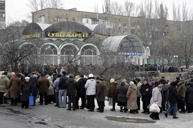 Local residents wait in a queue to get humanitarian aid near a grocery store in Donetsk, January 29, 2015. (Photo by Alexander Ermochenko/Reuters)