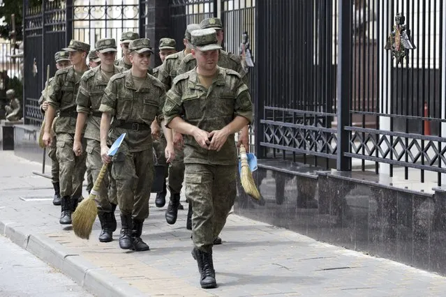 Russian soldiers walk to clean the area at the headquarters of the Southern Military District in Rostov-on-Don, southern Russia, Sunday, June 25, 2023. The armed rebellion by a powerful mercenary group against the Russian military was over in less than 24 hours, but the disarray within the enemy’s ranks was an unexpected morale-boosting gift for Ukraine – at a time when its armed forces needed it the most. (Photo by AP Photo/Stringer)