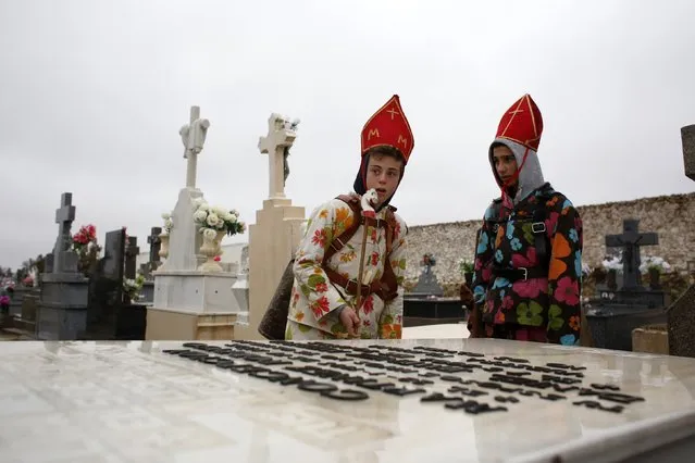 Young believers dressed as “diablos” (devils) stand by a tombstone at the cemetery during the “Endiablada” festival in Almonacid del Marquesado, in central Spain February 2, 2015. (Photo by Susana Vera/Reuters)