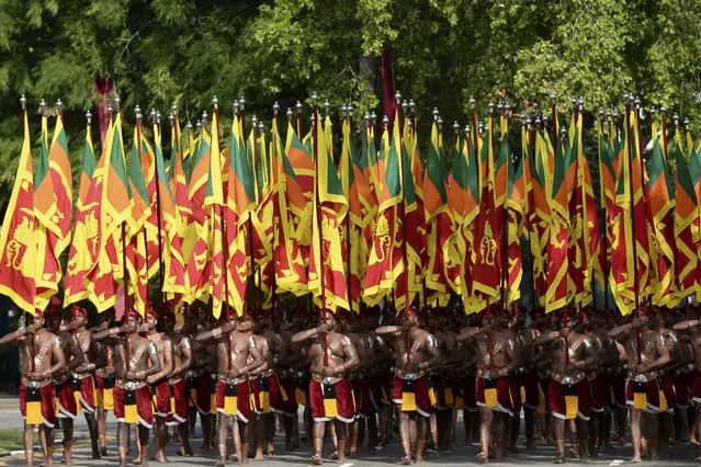 Sri Lankan military personnel with the army cultural troupe march wearing traditional dresses and holding national flags during the Sri Lanka's 73rd Independence Day celebrations in Colombo on February 4, 2021. (Photo by Lakruwan Wanniarachchi/AFP Photo)