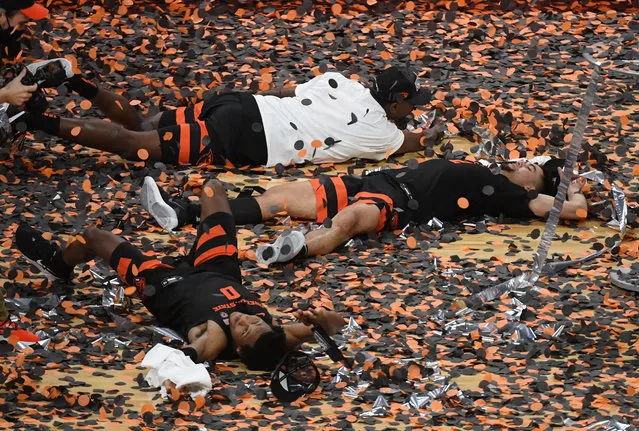 Gianni Hunt (bottom) #0 and Jarod Lucas (C) #2 and Dearon Tucker (top) #35 of the Oregon State Beavers celebrate in confetti after the team's 70-68 victory over the Colorado Buffaloes to win the championship game of the Pac-12 Conference basketball tournament at T-Mobile Arena on March 13, 2021 in Las Vegas, Nevada. (Photo by Ethan Miller/Getty Images via AFP Photo)