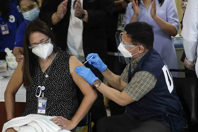 Health Secretary Francisco Duque III, right, injects China's Sinovac vaccine on Filipino doctor Eileen Aniceto during the first batch of vaccination at the Lung Center of the Philippines in Quezon city, Philippines on Monday, March 1, 2021. The Philippines launched a vaccination campaign Monday to contain one of Southeast Asia's worst coronavirus outbreaks but faces supply problems and public resistance, which it hopes to ease by inoculating top officials. (Photo by Aaron Favila/AP Photo)