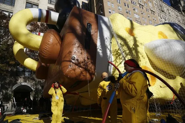 Workers help to inflate balloons for the Macy's Thanksgiving Day Parade in New York, Wednesday, November 23, 2016. (Photo by Seth Wenig/AP Photo)