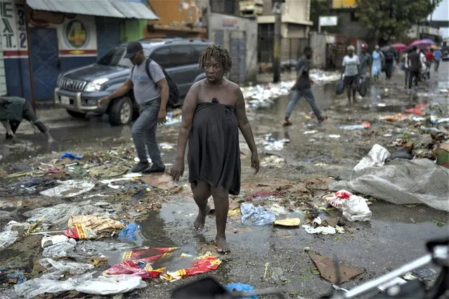 A woman walks on a street after a rain storm in Port-au-Prince, Haiti, Saturday, June 3, 2023. (Photo by Ariana Cubillos/AP Photo)