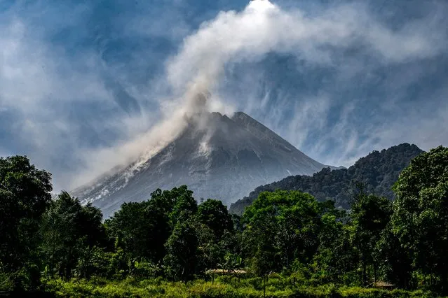 Mount Merapi billows smoke into the air and lava onto its slopes during its eruption as seen from Hargobinangun village, in Sleman on July 27, 2023. (Photo by Devi Rahman/AFP Photo)