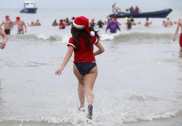 A participant runs towards the waters of the North Sea during the annual New Year's plunge event in Ostend, Belgium, January 2, 2016. (Photo by Francois Lenoir/Reuters)