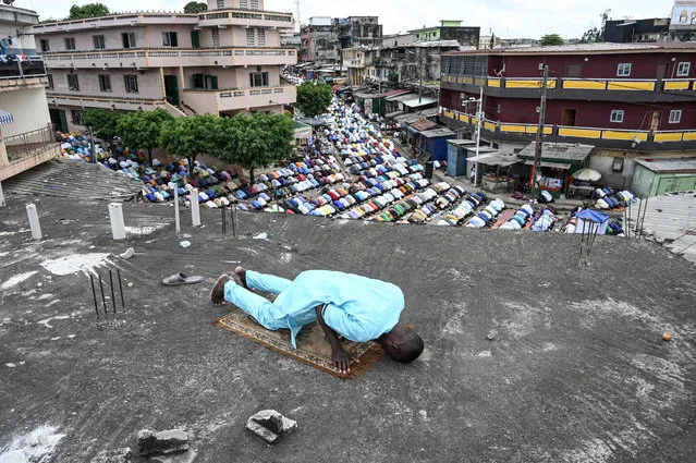 A Muslim prays during the Eid al-Fitr morning prayer, marking the end of the holy fasting month of Ramadan, on a rooftop in Adjame, a popular district of Abidjan, on May 2, 2022. (Photo by Sia Kambou/AFP Photo)