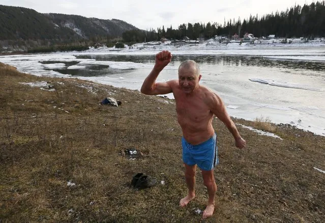 Vladimir Khokhlov, 71, a member of the Cryophile winter swimmers club, warms up after bathing in the icy water of the Mana river in Taiga district outside the Siberian city of Krasnoyarsk, Russia, November 6, 2015. The air temperature was about minus 5 degrees Celsius. A retired builder, Khokhlov now works as a caretaker in Krasnoyarsk. "I can't live without bathing daily in cold water, it's like a drug," he says. "If there's no river nearby I have to find another way to pour cold water over myself from head to foot". (Photo by Ilya Naymushin/Reuters)