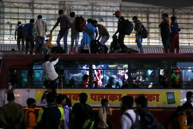 Migrant workers stand on top of an overcrowded bus to return to their villages after Delhi government ordered a six-day lockdown to limit the spread of the coronavirus disease (COVID-19), in Ghaziabad on the outskirts of New Delhi, India, April 19, 2021. (Photo by Adnan Abidi/Reuters)