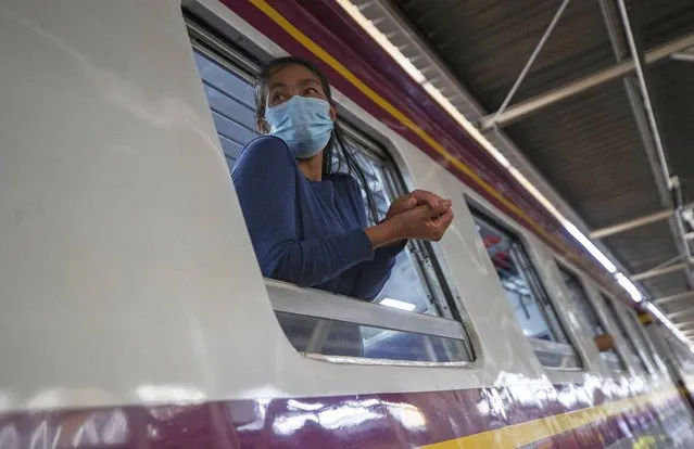 A passenger looks out from window on train bound for northeastern province of Ubon Ratchathani, at Hua Lamphong Railway Station in Bangkok, Thailand, Friday, April 9, 2021. Thai authorities were struggling Friday to contain a growing coronavirus outbreak just days before the country's traditional Songkran New Year's holiday, when millions of people travel around the country. (Photo by Sakchai Lalit/AP Photo)