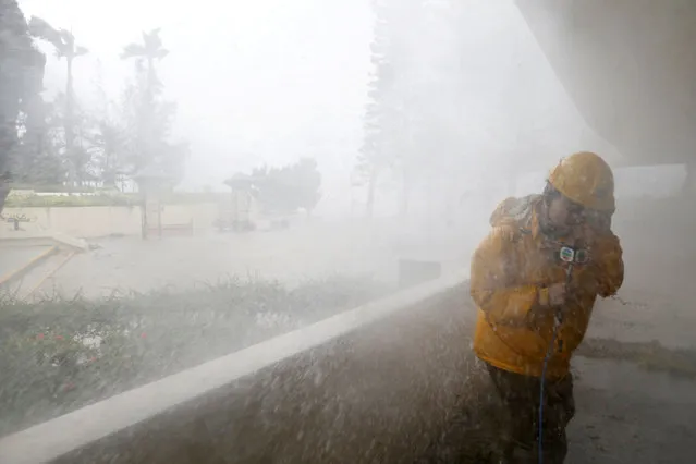 A journalist braves high waves at Heng Fa Chuen, a residential district near the waterfront, under Typhoon Mangkhut attack in Hong Kong, China September 16, 2018. (Photo by Bobby Yip/Reuters)