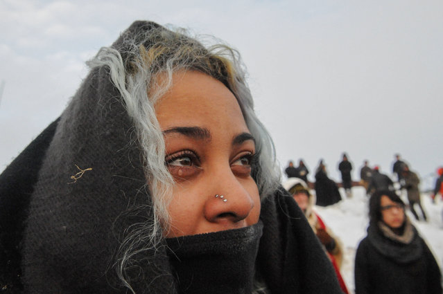 A woman cries during the sunrise in Oceti Sakowin camp as "water protectors" continue to demonstrate against plans to pass the Dakota Access pipeline near the Standing Rock Indian Reservation, near Cannon Ball, North Dakota, U.S. December 3, 2016. (Photo by Stephanie Keith/Reuters)