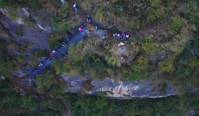 Students from “the cliff village” in Atule'er climb newly-constructed steel ladders after school to go home for holidays, in Liangshan, Sichuan province, China, November 19, 2016. (Photo by Reuters/Stringer)