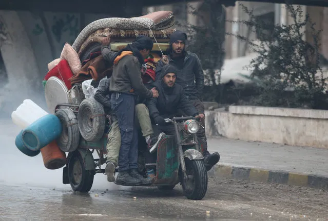 Men ride a tricycle as they flee deeper into the remaining rebel-held areas of Aleppo, Syria December 7, 2016. (Photo by Abdalrhman Ismail/Reuters)