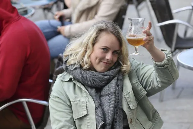 A woman holds up her beer glass, while seated in a cafe terrace, in Rennes, western France, Wednesday, May, 19, 2021. It’s a grand day for the French. Cafe and restaurant terraces are reopening Wednesday after a pandemic shutdown of more than six months deprived people of what feels like the essence of life in France. The French government is lifting restrictions incrementally to stave off a resurgence of COVID-19 and to give citizens back some of their signature “joie de vivre”. (Photo by David Vincent/AP Photo)